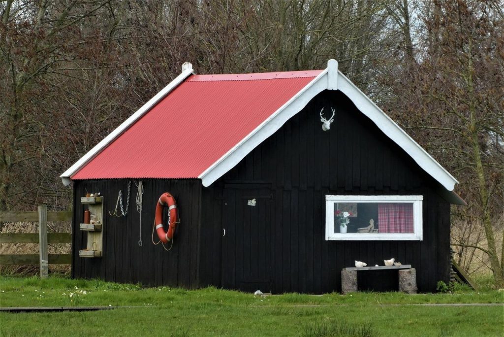 Houten blokhut op maat in een groene tuin, ideaal voor extra ruimte als werkplek, opslag of ontspanningsruimte